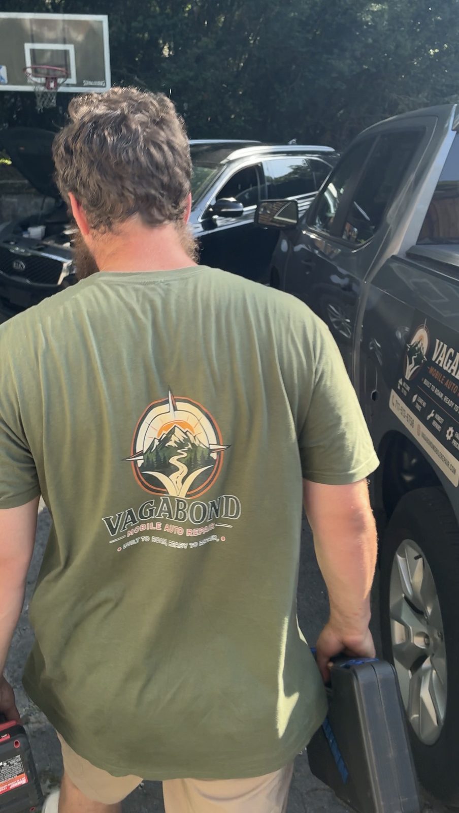 Vagabond Mobile Auto Repair technician in a branded shirt working beside a customer's truck
