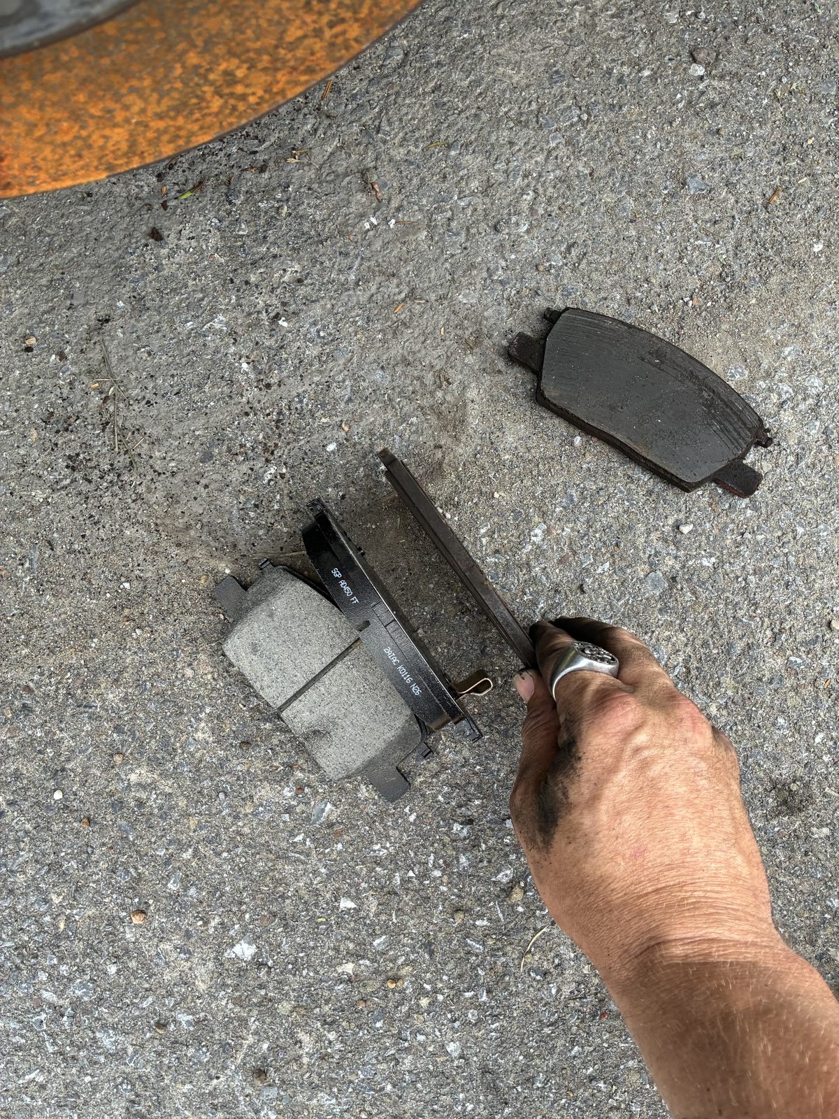 Comparison of worn old brake pads next to new replacement pads