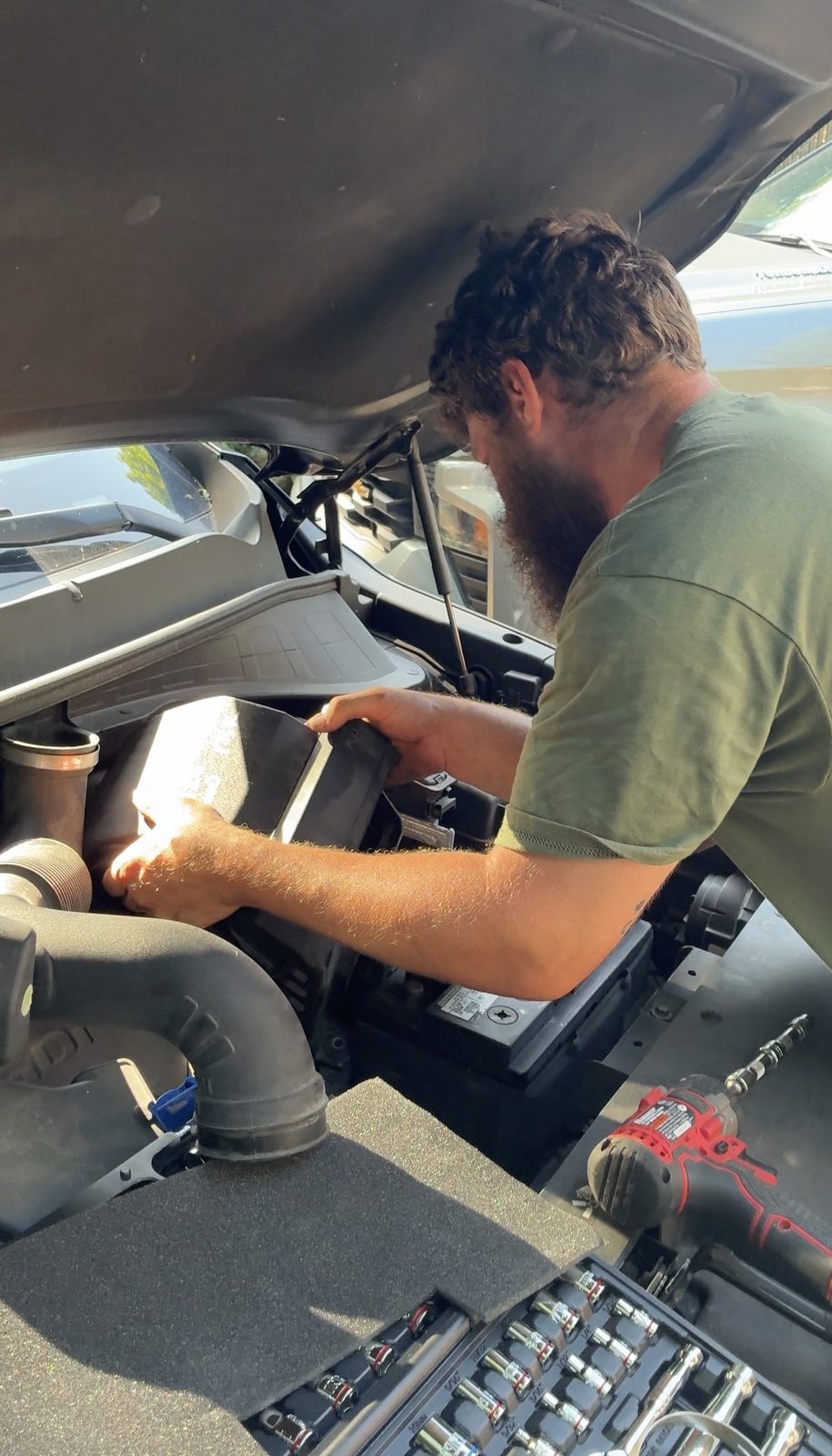 Under-hood maintenance work with a socket set laid out